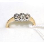 An 18 carat gold diamond three stone ring, graduated round brilliant cut diamonds in white rubbed