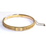 A Victorian 9 carat gold diamond set bangle, an old cut diamond in a yellow star setting with