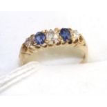 An 18 carat gold sapphire and diamond ring, three old cut diamonds spaced by two oval cut