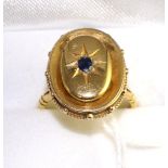 A sapphire plaque ring, an oval cut sapphire in a yellow star setting, to an oval plaque with a bead