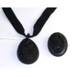 A carved jet pendant, of oval form and carved in high relief with a floral spray, on a black