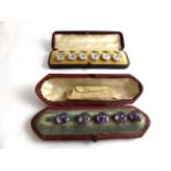 A cased set of six mother-of-pearl blue paste and enamel buttons, mother-of-pearl discs inset with a