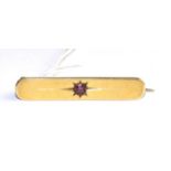An 18 carat gold bar ruby bar brooch, a round cut ruby in a star setting to a plain bar, length 4.