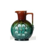 Christopher Dresser for Linthorpe Pottery: A Jug, shape No.805, moulded with a repeating designs