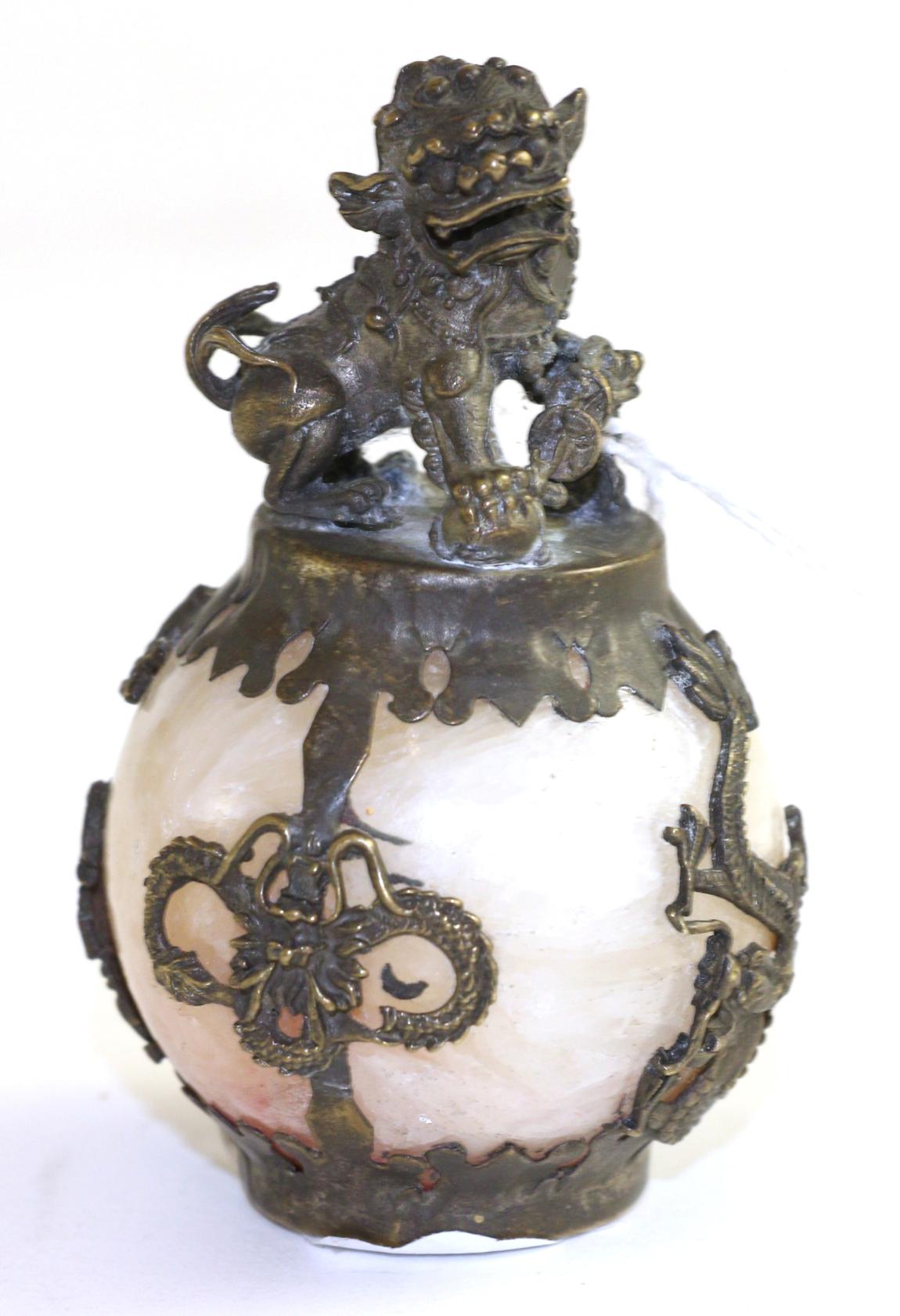 A Chinese gilt metal mounted hardstone ball, surmounted with a Fo Dog, with pierced dragons to the