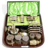 A group of silver condiments including a boxed set and an Art Deco toast rack marked ''Mappin & Webb