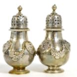 A pair of Victorian silver pepperettes, Lambert & Co, London 1899, with applied garlands and lion