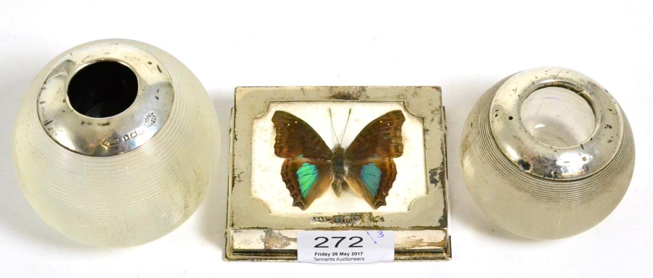 An Edwardian silver paperweight, mounted with a butterfly, and two silver mounted glass match balls,