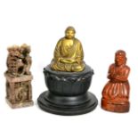 An Oriental carved and lacquered hardwood praying figure; another carved figure on ebonised base and