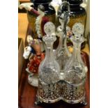 A silver plated triple glass decanter tantalus, three Continental figures and part tea sets