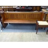 A large pitch pine church pew and a piano stool with hinged cover