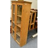 A pine glazed cabinet with four shelves and two drawers; and a pine stool (2)