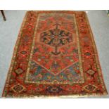 A North West Persian rug, the madder field with a lattice of stylised curved leaves around a stepped