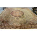 A large machine made carpet of Persian design, the cream field centred by a cusped medallions