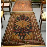 An Afghan Balouch rug, the field with a flowerhead medallion framed by spandrels and narrow borders,