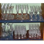 Two shelves of assorted drinking glasses including champagne flutes and wines together with