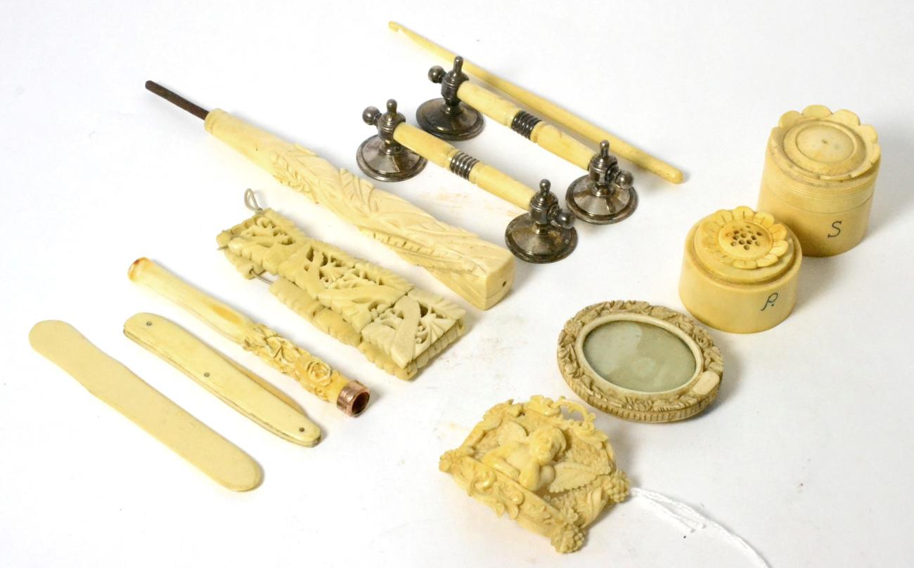 A carved ivory cruet set, a carved ivory plaque, knife rest, a cheroot holder and a parasol handle