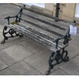 A Victorian wooden slatted cast iron garden bench with dog form arms, probably Coalbrookdale