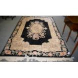 A Savonerie design carpet, the jet black field centred by a floral oval medallion framed by