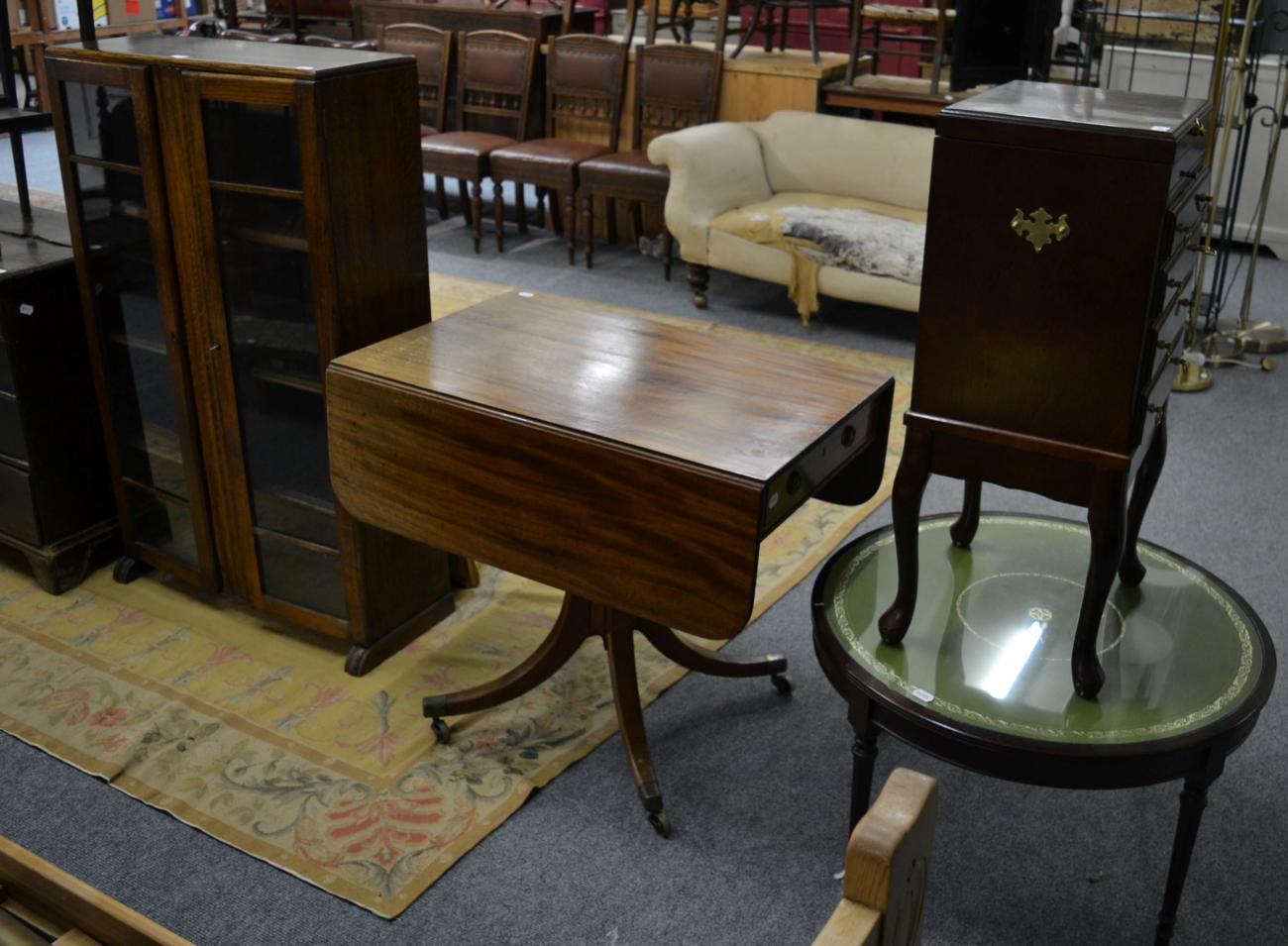 A 20th century oak glazed bookcase; an oval topped side table and a mahogany Pembroke table on