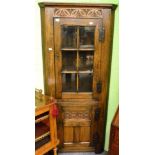 A reproduction oak standing corner cupboard