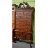 A reproduction hardwood chest on stand, the ornate carved swan neck pediment above two short and