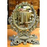 A 19th century cast iron toilet mirror with electrode foliate frame sconce