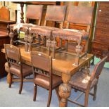 A matched dining suite comprising a carved oak and walnut sideboard, oak drawer leaf dining table,