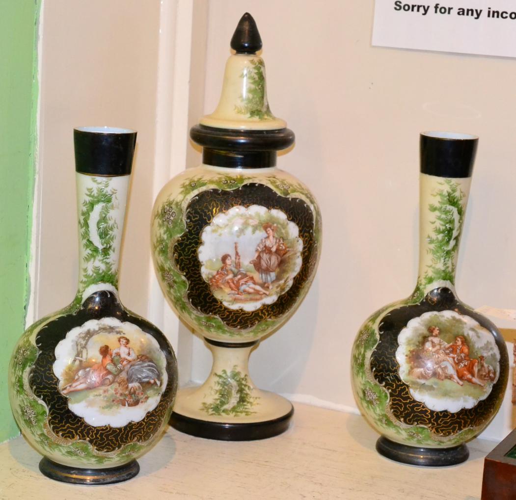 A set of three Victorian painted glass vases decorated with vignettes of courting couples