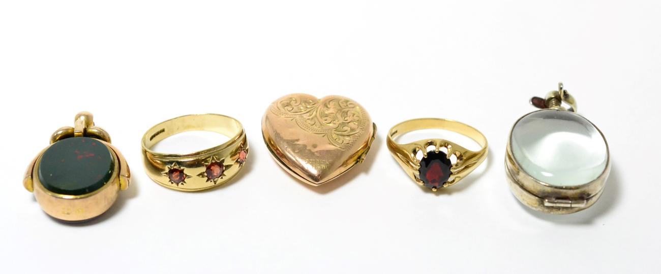 A hardstone swivel fob, a crystal locket, a heart locket and two 9ct gold garnet rings (5)Two 9ct