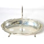 A silver dish with swing handle by H E Ltd, Sheffield 1911, raised on stepped feet