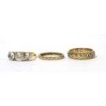 An 18ct gold cubic zirconia three stone ring, an eternity ring and another eternity ring (3)Cubic