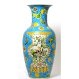 A Chinese porcelain baluster vase decorated with a vase to either side on a blue ground with