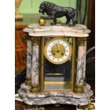 A marble four glass striking mantel clock, surmounted by a lion