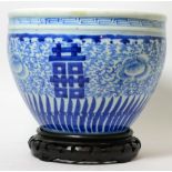 An early 20th century blue and white Chinese jardiniere with partial import seal and hardwood
