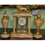 A gilt metal mounted striking clock garniture surmounted by a lion