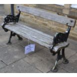 A Victorian slatted wooden garden bench with cast iron ends