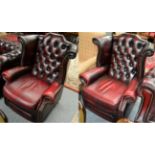 A pair of George III style ox blood leather wingback armchairs