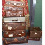 A group of nine leather, canvas and other suitcases and trunks of various size
