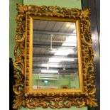 A reproduction gilt framed wall mirror 114cm tall by 89cm wide.