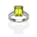 An 18 Carat White Gold Peridot and Diamond Ring, an octagonal cut peridot in a claw setting, to