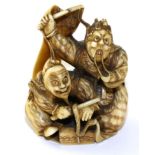 A Japanese Ivory Netsuke, Meiji period, as two actors wearing Noh masks and holding a banner,