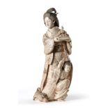 A Japanese Ivory Okimono of a Geisha, Meiji period, standing holding a figure of an immortal, a