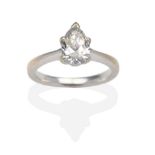 A Pear Cut Diamond Solitaire Ring, in a white claw setting, to knife edge shoulders on a plain