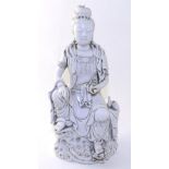 A Blanc de Chine Figure of Guanyin, Qing Dynasty, sitting on a rock holding a scroll, a vase and