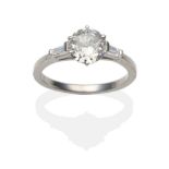 A Platinum Diamond Solitaire Ring, an old cut diamond in a claw setting between tapered baguette cut