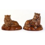 A Pair of Treacle Glazed Pottery Figures of Lions, possibly Brameld, circa 1840, the recumbent