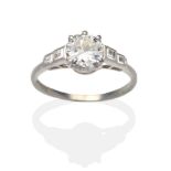 A Diamond Solitaire Ring, an old cut diamond in a white claw setting to shoulders each set with