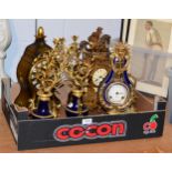 A group of reproduction clocks including a figural mantle clock surmounted by a horse and rider, a
