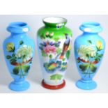 A pair of floral painted Victorian blue glass vases and another example painted with birds